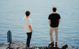 Two men in essential tees standing by a Lake in Vermont